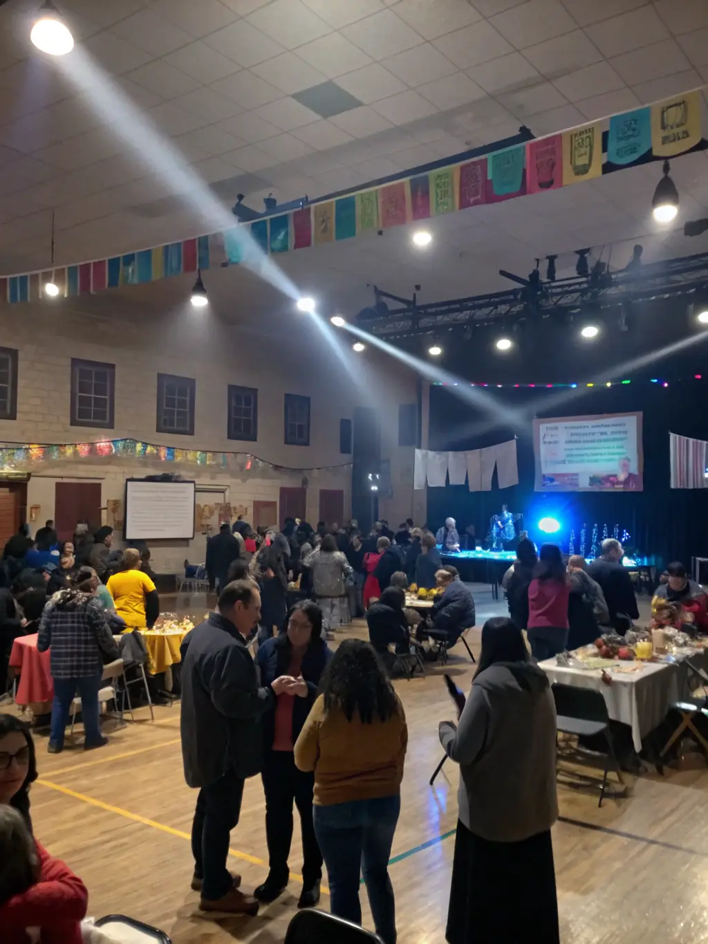 A photo of a public screening of restored historical footage in a community center, highlighting the impact of making audiovisual content accessible to the public.